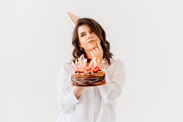 a funny woman with a birthday cake with candles.