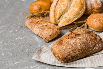 Homemade natural breads. Different kinds of fresh bread as background, perspective view with copy space
