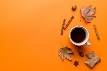 Flat lay composition with colorful Autumn cup of coffee and leaves on a color background. top view