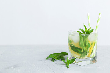 Mojito summer refreshing cocktail with ice and mint. mojito cocktail with lime, lemon and mint in a tall glass with a stick