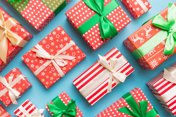 A lot of Christmas gift boxes in colored paper decorated on table, Top view close up. Many present New Year gift