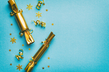 Christmas crackers with shiny confetti on color background, top view, copy space