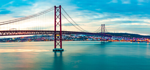 Paisaje de Lisboa al atardecer. Fotografía panorámica del puente 25 de Abril de la ciudad de Lisboa sobre el río Tajo.