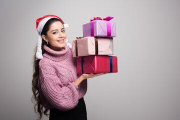 Happy pretty woman holding stack of gift boxes