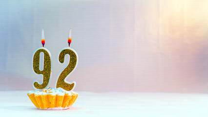 Happy birthday card from candles with the number 92 , golden numbers from candles for congratulations on any holiday.