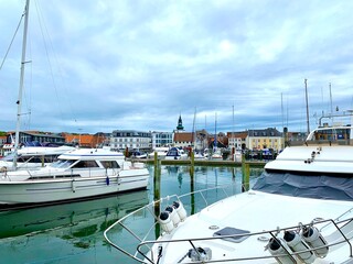 view from a harbor pier on the Limfjord over boats and sailing yachts in the direction of Lemvig...
