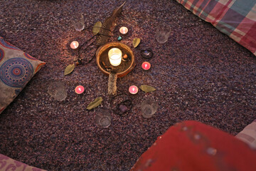 Raw cacao set with flowers candles, feathers, Palo Santo, bay leaves, and pillows for the shamanic ceremony © Delphine