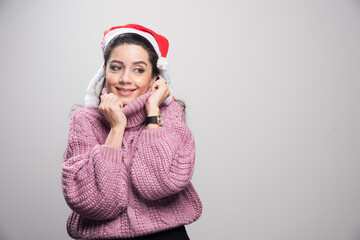Cheerful attractive sensual young woman in santa hat and sweater
