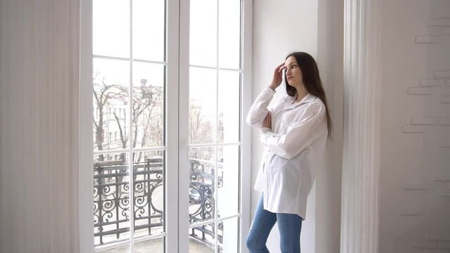 Slow Motion woman looking out window at home