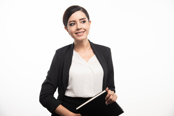 Smiling woman posing with notebook on white background