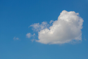 Beautiful white fluffy cloud floating in blue sky in sunny day, Cumulus are clouds which have flat bases and are often described as puffy, Horizon nature background with free copy space.