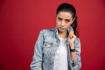 Casual looking woman looking at camera on red background