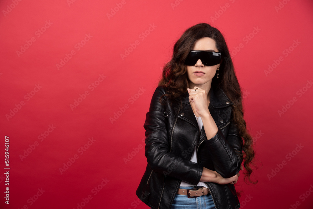 Sticker Young woman wearing black glasses on a red background