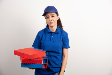 Young female courier with cardboard of pizza and clipboard