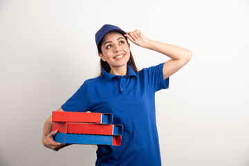 Young female courier with cardboard of pizza and clipboard