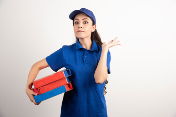 Portrait of young woman in uniform smiling and delivering pizza