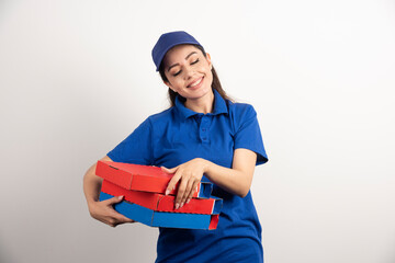 Portrait of young woman in uniform smiling and delivering pizza