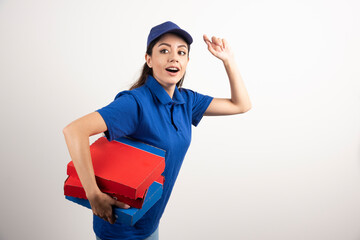 Portrait of young woman in uniform smiling and delivering pizza