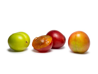 Cherry plum at different stages of maturation. Plum variety. Red and green fruits. Tkemali. Juicy fruit on the table.