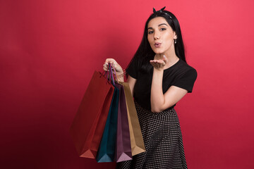 Woman showing her bags on red background
