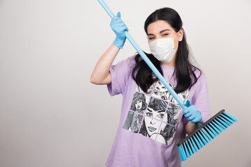 Woman with facemask and mop on white background