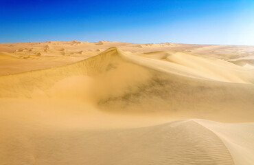 Fototapeta na wymiar sand dunes in the desert with blue sky - Dunas de Ica, Desierto De Ica, Peru
