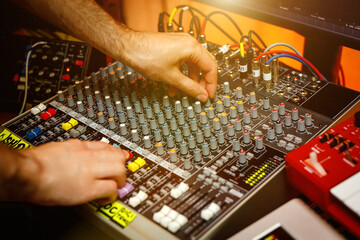 Hand of a sound engineer on sound console mixer. Equalizer control