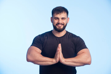 Sportive man in black shirt uniting his hands