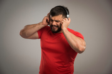 Male dj in red shirt wearing headphones and singing