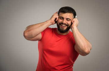 Male dj in red shirt wearing headphones