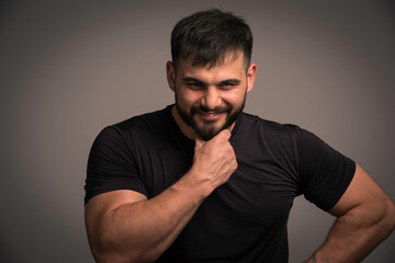 Sportive man in black shirt smiling and looks confident