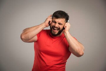 Male dj in red shirt wearing headphones and singing