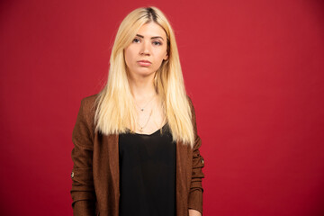 Fototapeta premium Businesswoman in casual outfit standing on red background