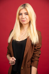 Fototapeta premium Young businesswoman in casual outfit standing on red background