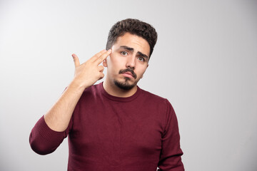 A sad brunette man posing with his hands