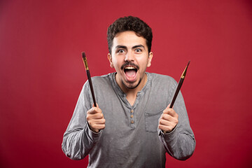 Artist holding his brand new brushes and feels very inspired about creating art