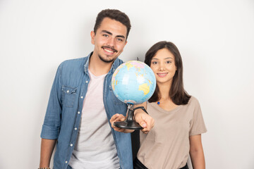 Man and woman holding earth globe on white background