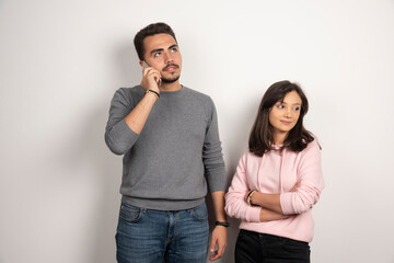 Woman standing while man talking with telephone