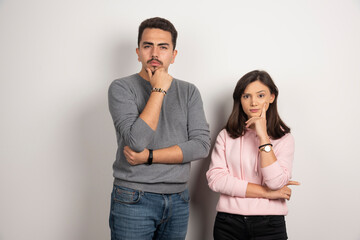 Young couple thinking on white background