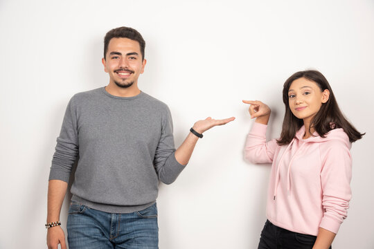 Sweet Couple Pointing At Themselves On White Background