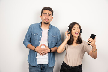 Young man feeling down while woman singing a song