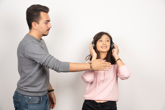 Young Man Trying To Stop The Woman Who Is Listening To Music