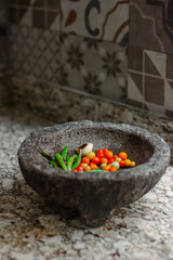 Traditional Mexican molcajete with chilli peppers , cherry tomatoes and garlic