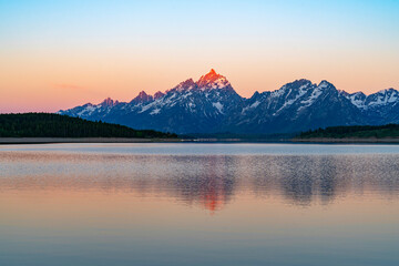landscape of snow mountain teton under morning sunlight reflecting in the lake
