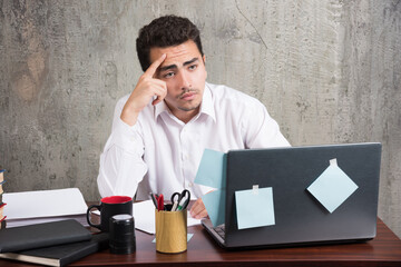 Office employee looking at laptop at the office desk