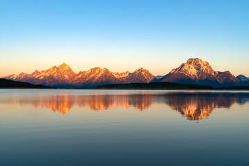 paysage de montagne enneigée sous la lumière du soleil du matin se reflétant dans le lac