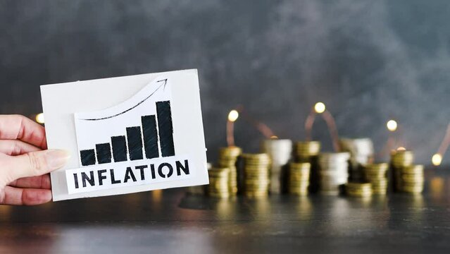 consumer prices increase and inflation going up, graph with stats and text in front of stacks of coins with fairy lights