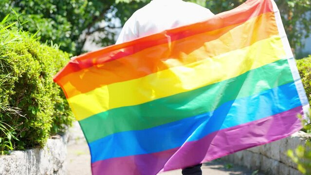 虹の旗を振る男性　LGBTイメージ