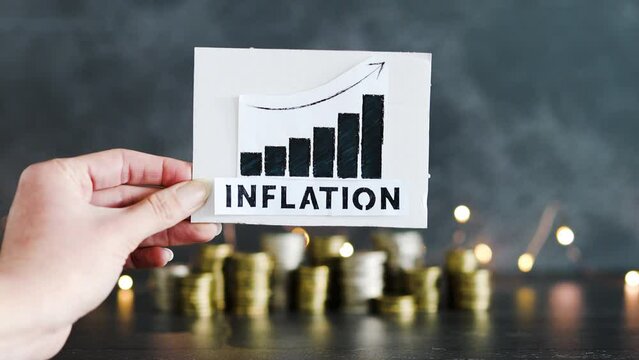consumer prices increase and inflation going up, graph with stats and text in front of stacks of coins with fairy lights