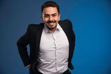 Obraz premium Businessman in black suit smiling positively